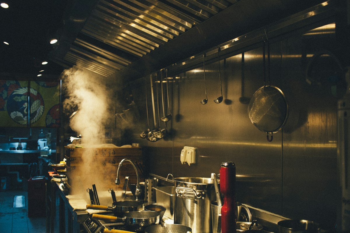 Steam rising from pots under a kitchen extraction hood