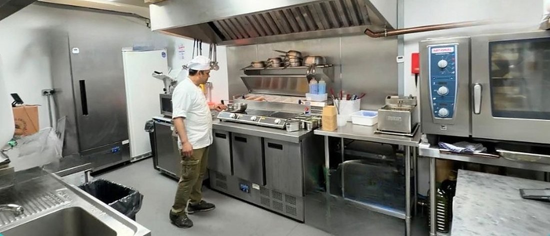 A fitted delivery kitchen at Ready Kitchen with a combi oven, prep counters and a chef at work